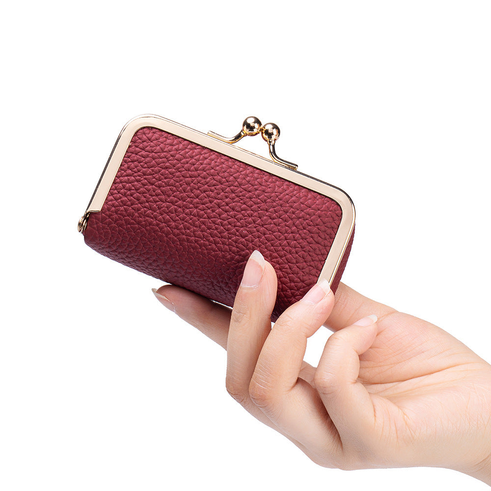 Burgundy pebbled pouch held in hand to show compact scale