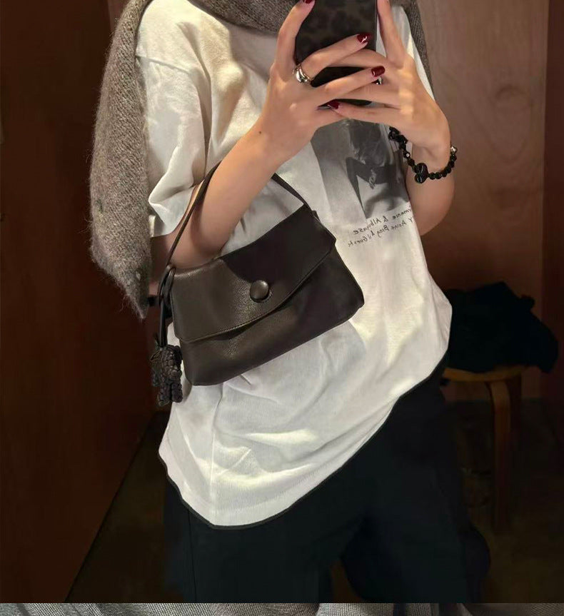 Compact button flap shoulder bag styled with a casual outfit