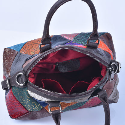 Close-up of dark shoulder strap attachment and embossed leather panels