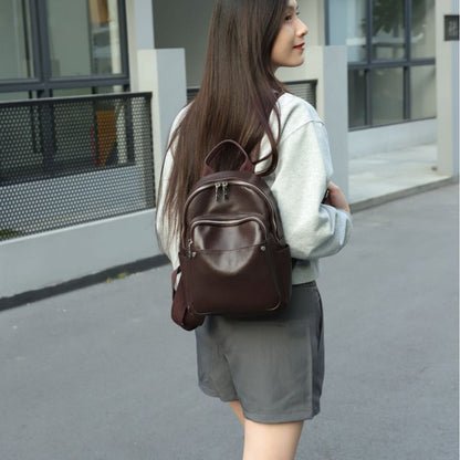 Brown leather backpack shown from the rear on a model