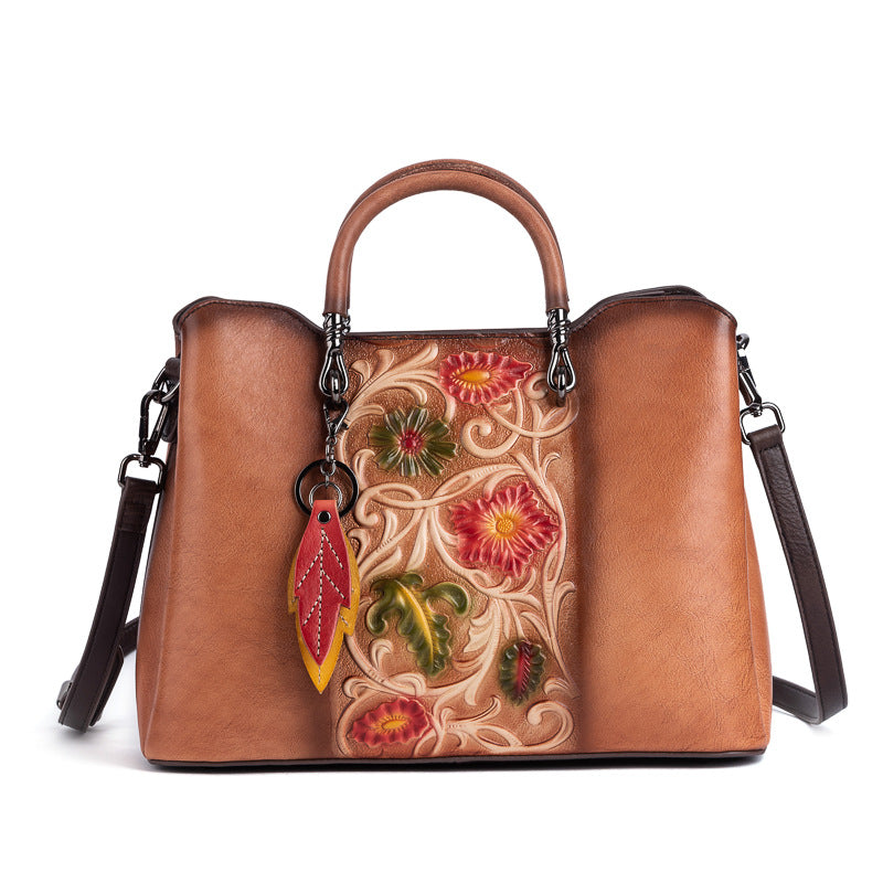 Front view of brown floral cowhide bag with detachable strap
