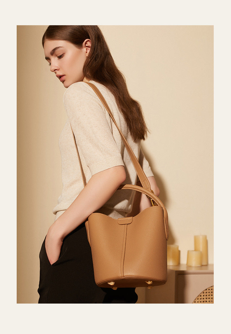 Model carrying biscuit bucket bag crossbody style in lifestyle setting
