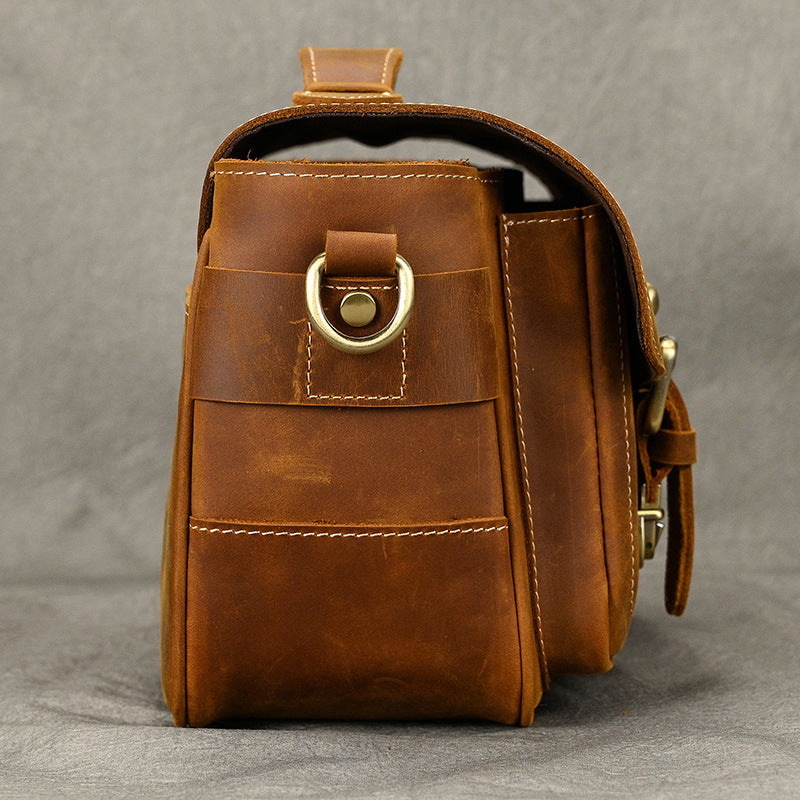 Side view of brown camera bag with metal strap ring