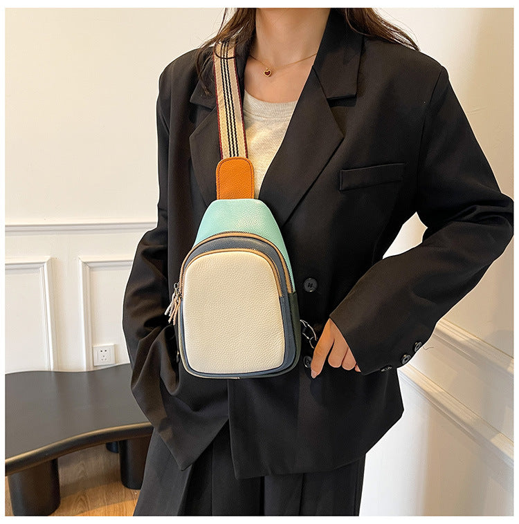Cream-front leather sling bag worn with a blazer