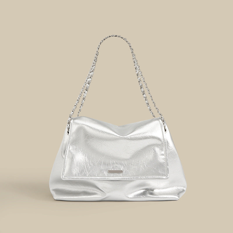Silver metallic cowhide leather slouchy chain shoulder bag on neutral background