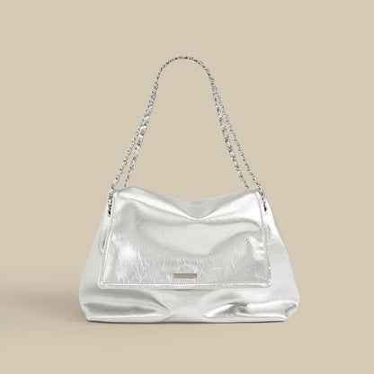 Silver metallic cowhide leather slouchy chain shoulder bag on neutral background