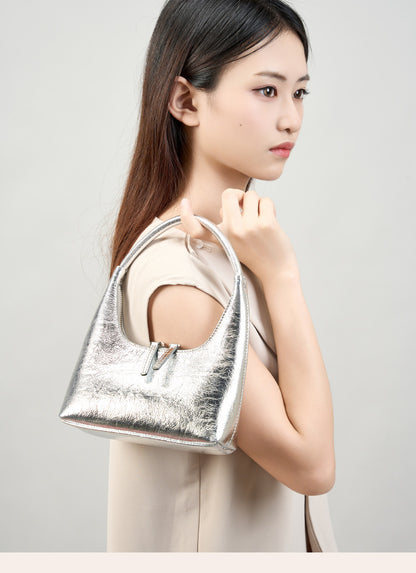 Model wearing silver mini hobo bag on the shoulder, side view
