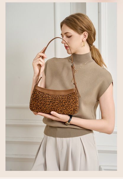 Close-up of the zipper pull and stitched trim on the small bag