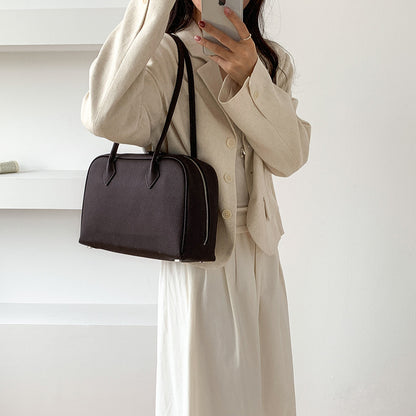 Coffee brown Boston bag carried on the shoulder