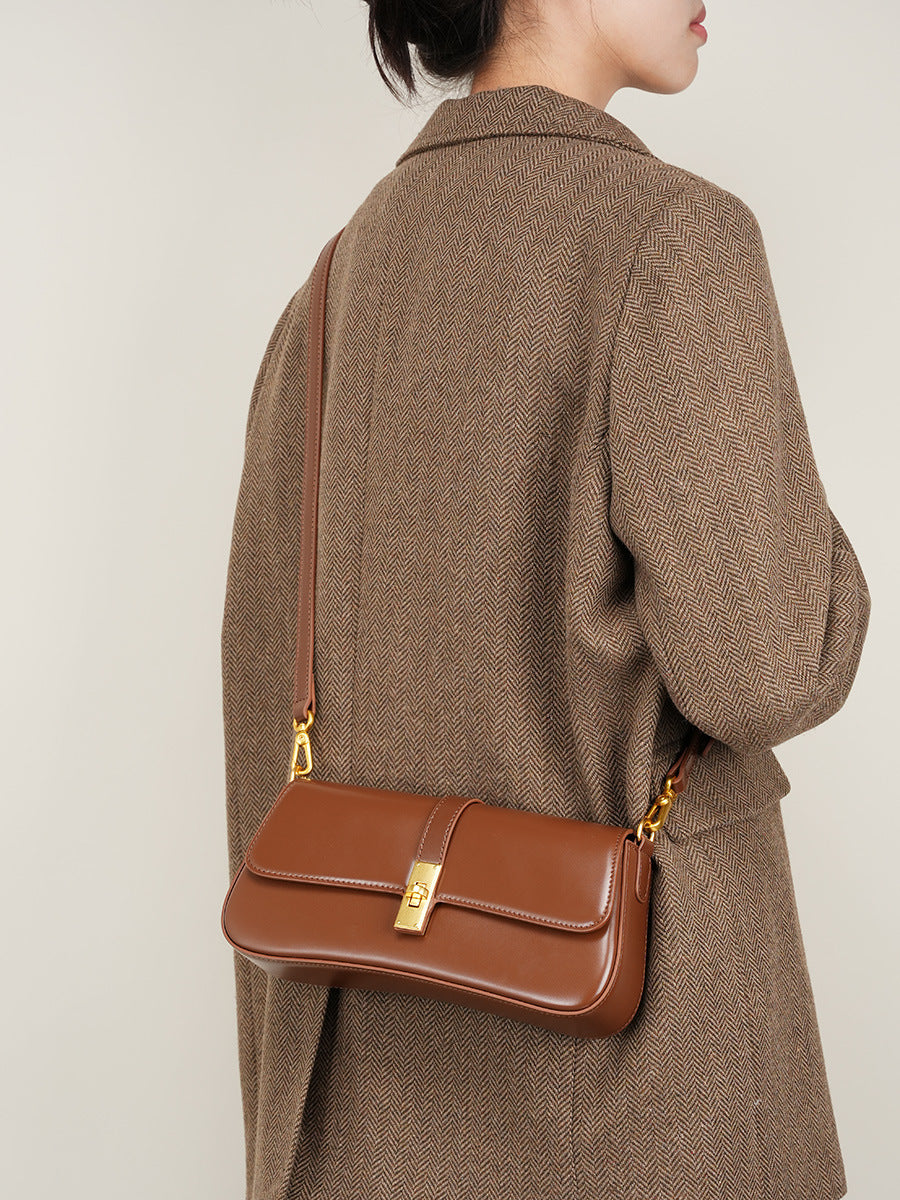 Back view of model carrying the structured mini leather shoulder bag with dual straps