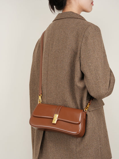 Back view of model carrying the structured mini leather shoulder bag with dual straps