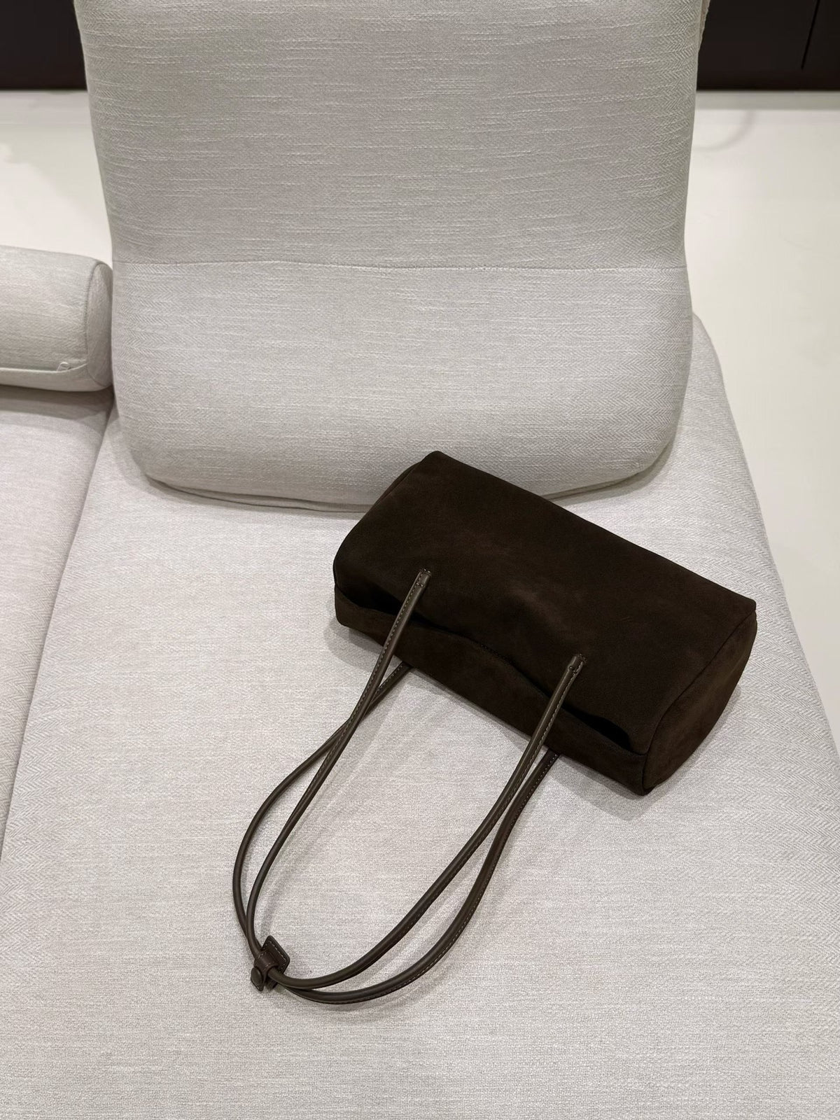 Underside and handle attachment detail of the dark brown tote