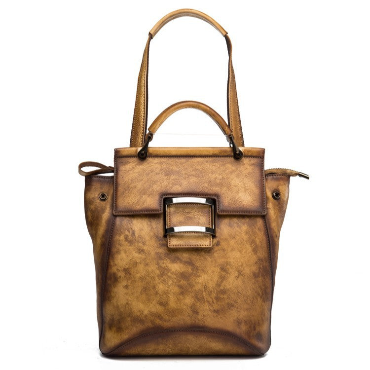 Angled view of the coffee brown backpack with its long shoulder strap visible