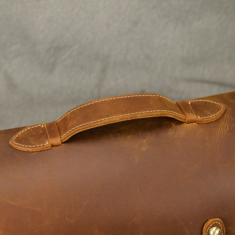 Close-up of the stitched top handle on the leather bag