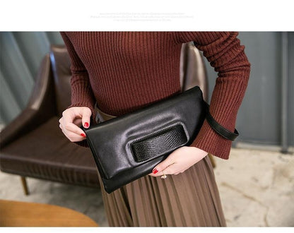 Model carrying a black clutch with textured black accent panel