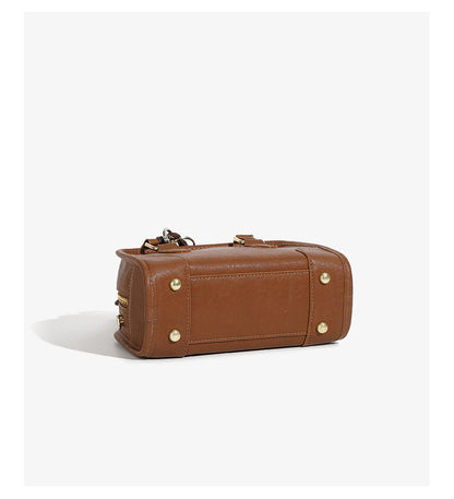 Bottom view of brown mini bowling bag showing protective base studs