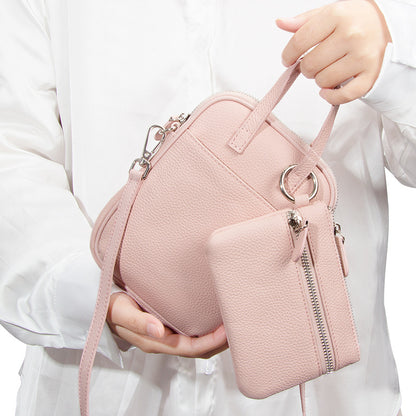 Peony Pink Mara crossbody bag held by model showing scale and strap
