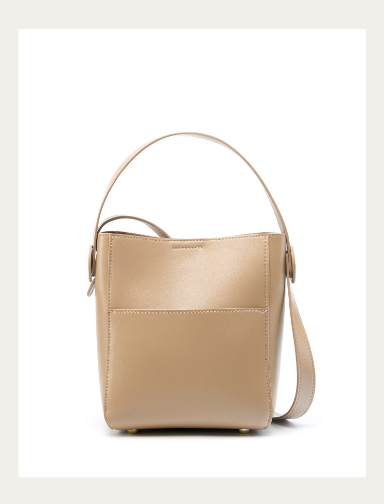 Apricot cowhide bucket crossbody bag with top handle on white background