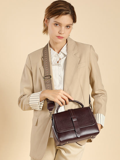 Model carrying the wine brown Boston crossbody bag on a wide patterned shoulder strap