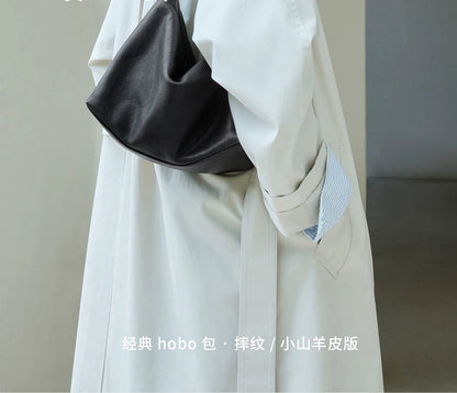 Close-up of black leather hobo bag texture and curved base