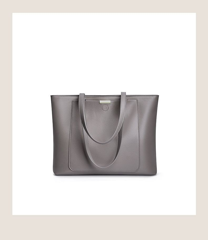 Front view of dark gray pebbled leather tote with logo plate and patch pocket