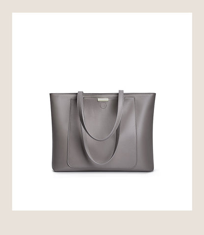 Front view of dark gray pebbled leather tote with logo plate and patch pocket