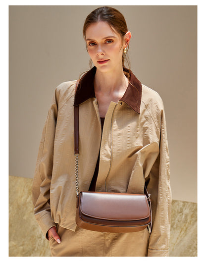 Front view of a brown cowhide baguette bag with chain strap on model
