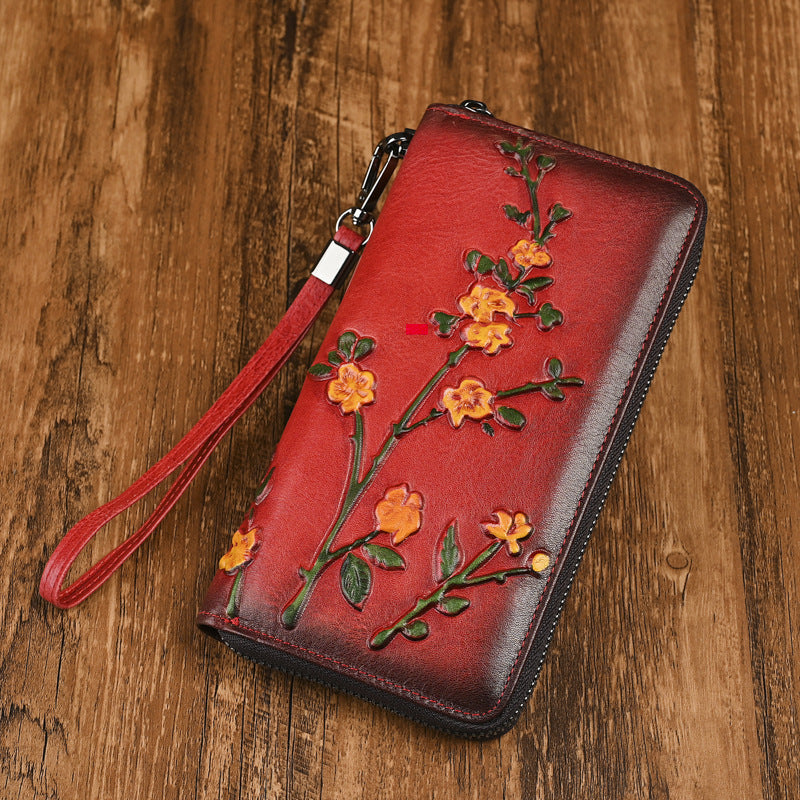Red leather wallet with raised floral decoration and zip closure