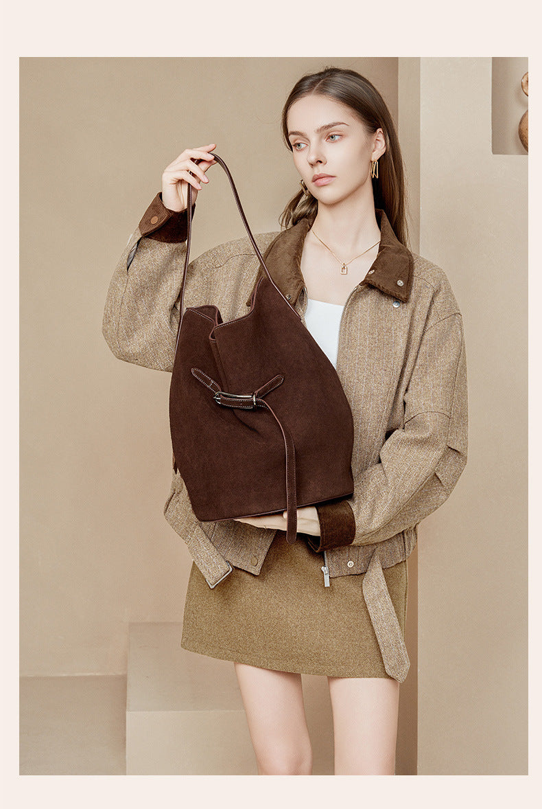 Coffee suede tote displayed by its shoulder strap