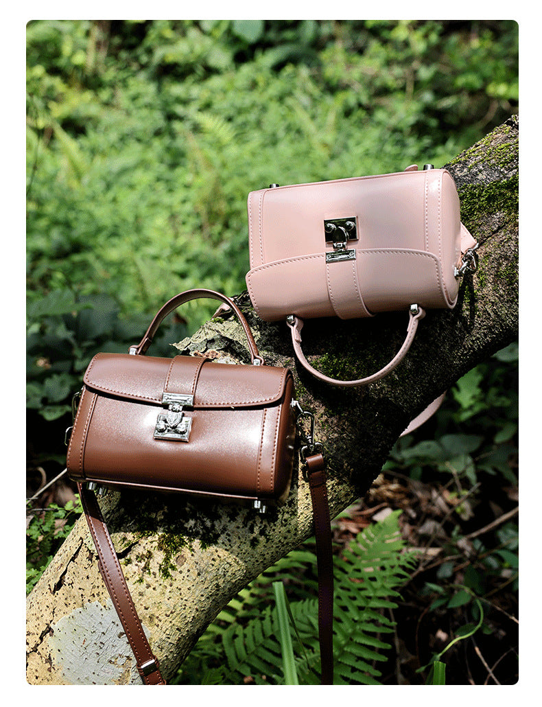 Brown and pink cowhide leather mini box bags arranged on a mossy tree branch