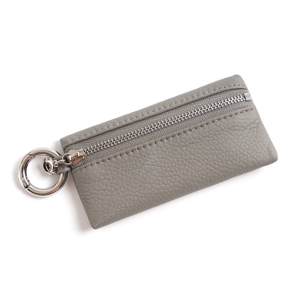 Light gray top-grain cowhide mini coin purse with silver swivel keyring on white background