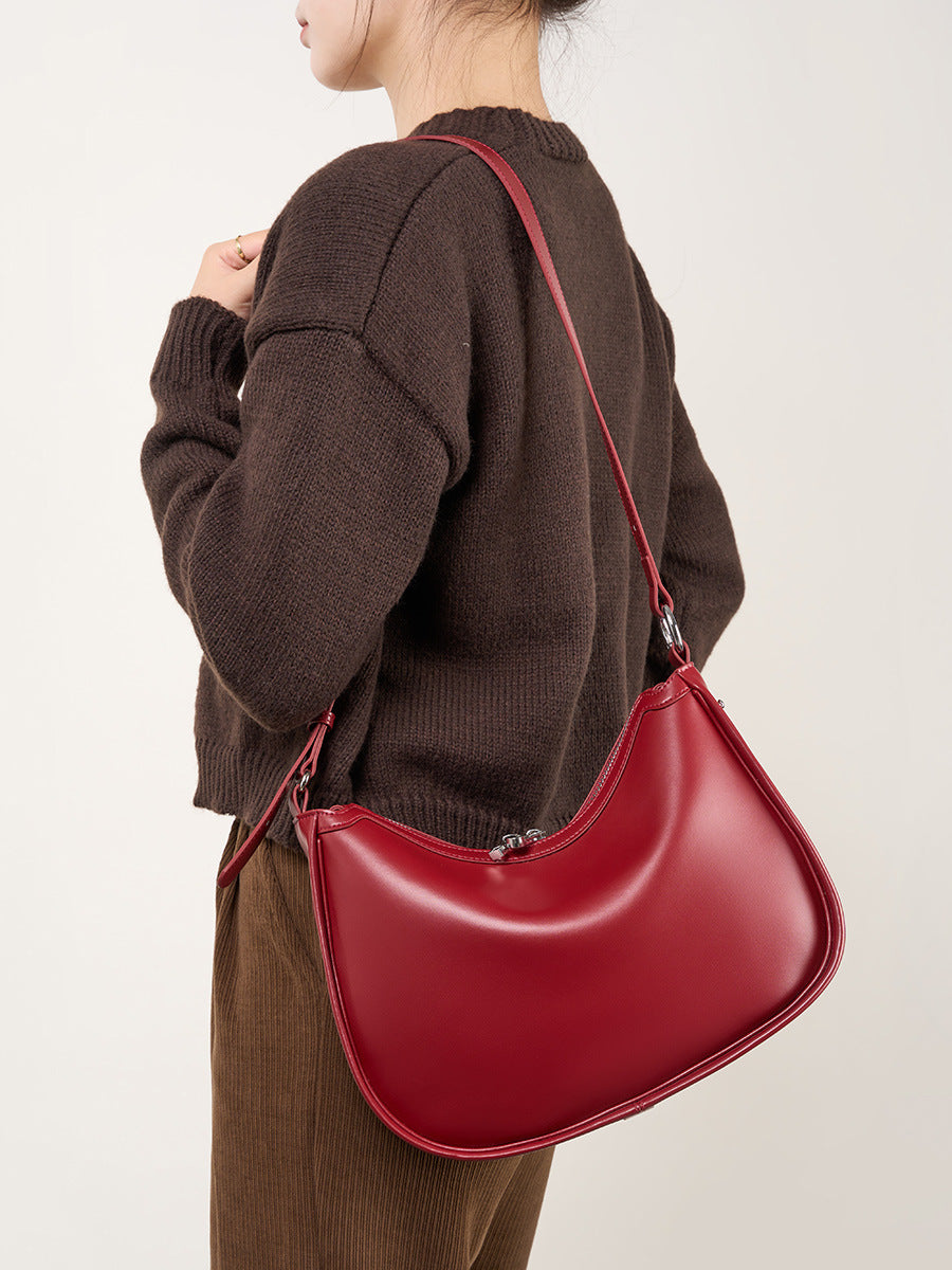 Model wearing burgundy leather crescent bag crossbody