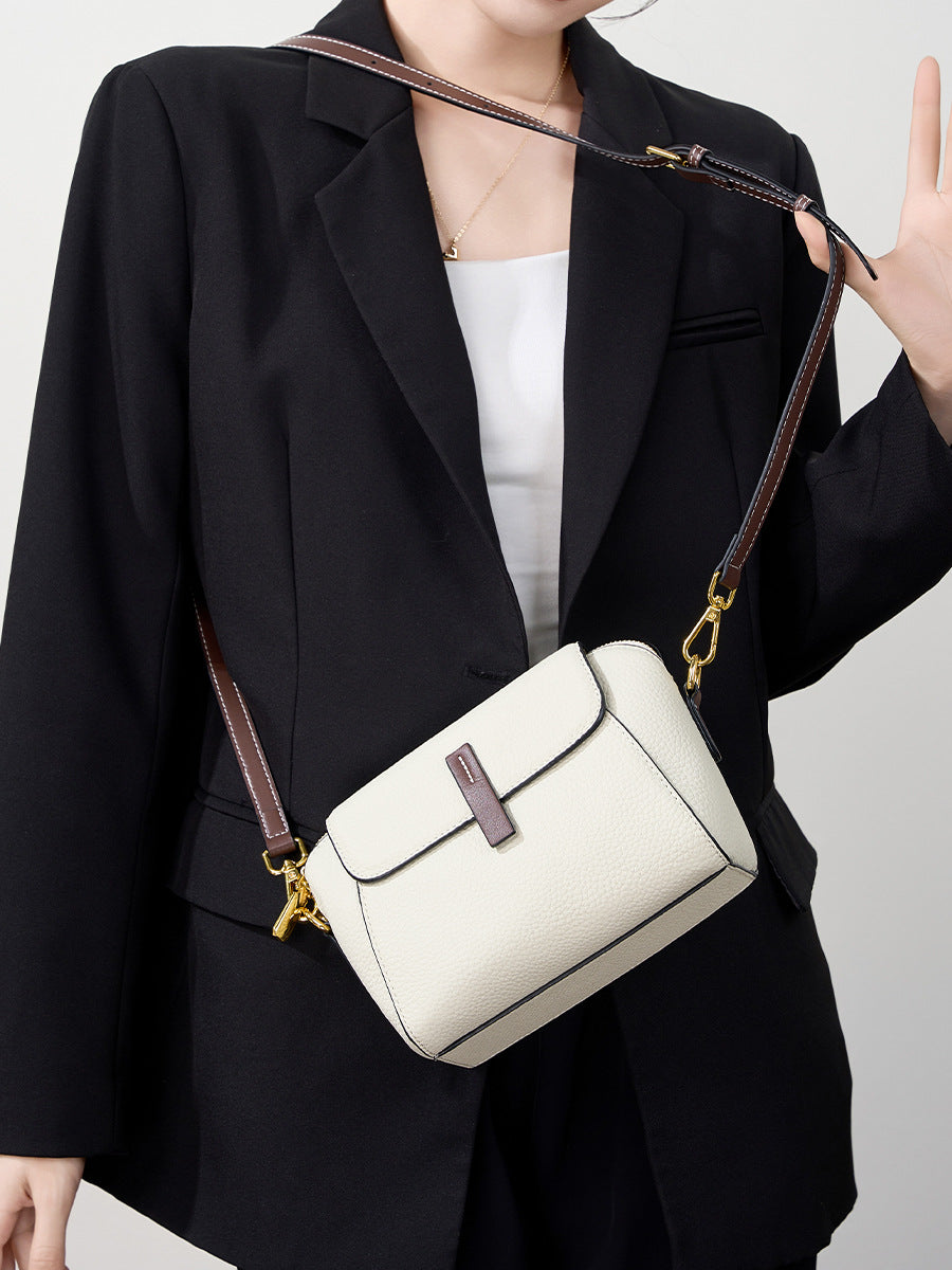 Ivory shell crossbody bag worn crossbody over a black blazer