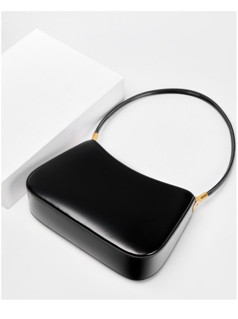 Black shoulder bag viewed from above with strap laid flat
