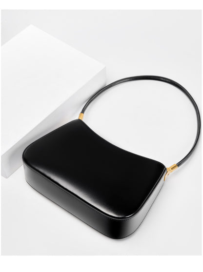 Black shoulder bag viewed from above with strap laid flat