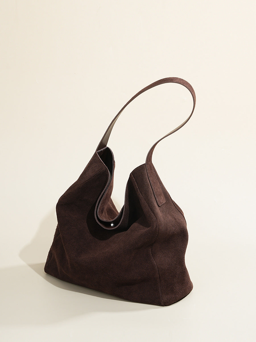 Angled view of the soft-sided brown leather shoulder tote