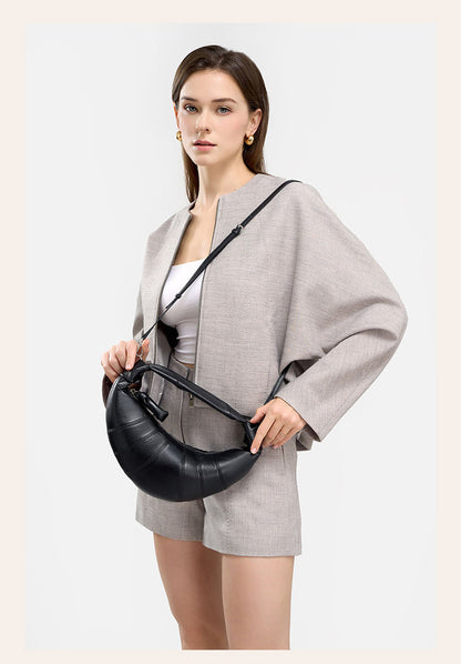Model wearing black crescent bag with adjustable crossbody strap
