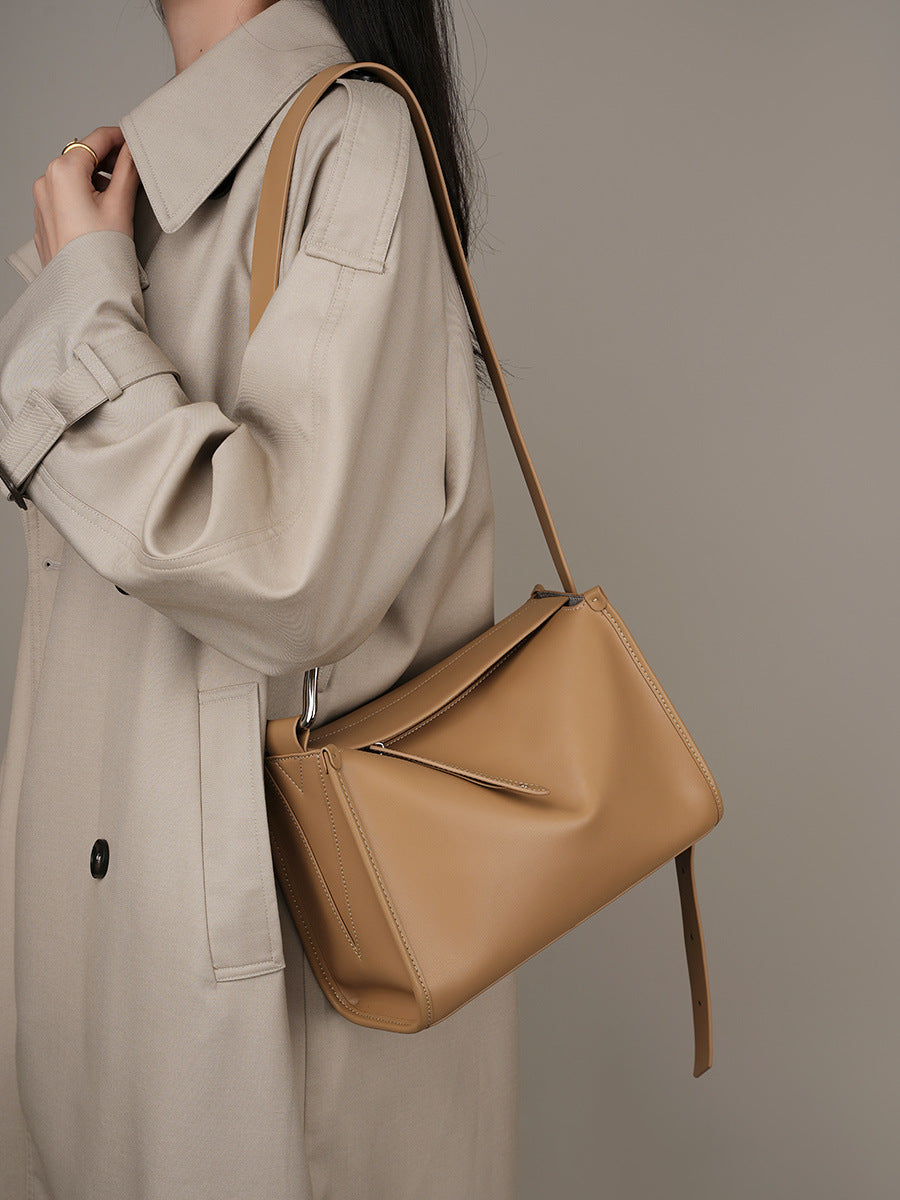 Apricot pillow bag styled over shoulder with beige trench