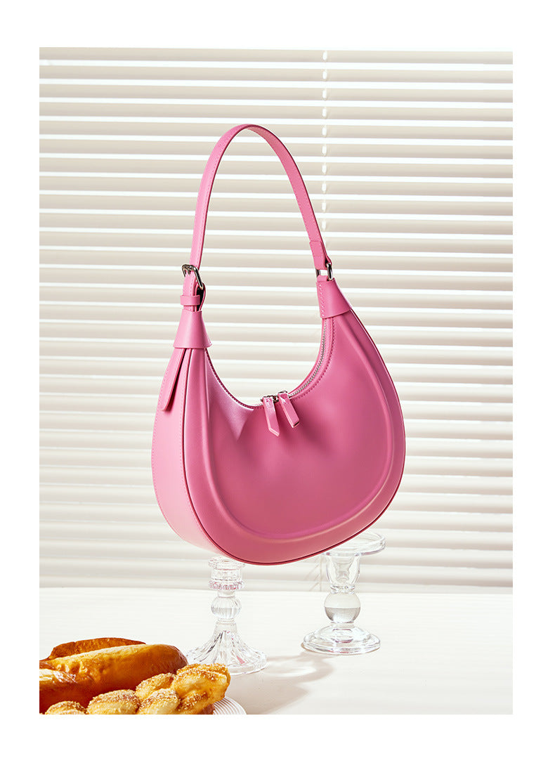 Cherry blossom pink crescent bag displayed with pastries on crystal stands