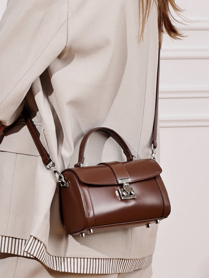 Brown cowhide leather mini box bag worn crossbody with a beige blazer