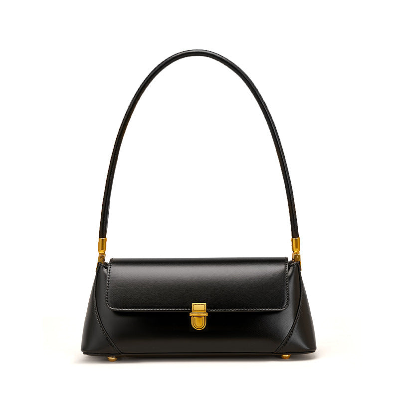 Black cowhide baguette bag with brass push lock on white background