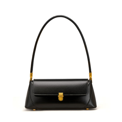 Black cowhide baguette bag with brass push lock on white background