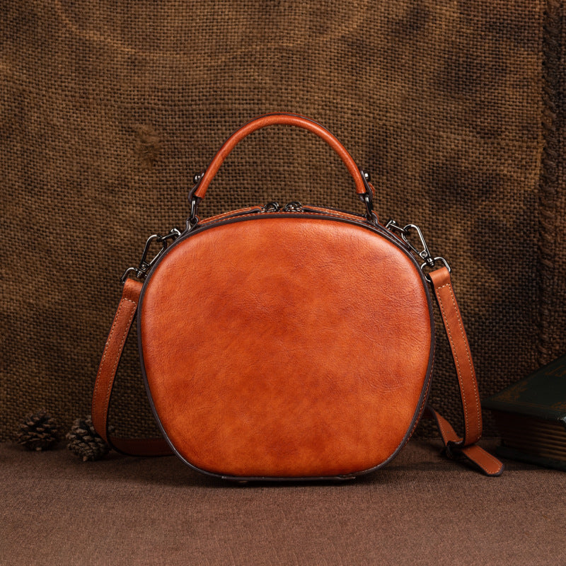 Back view of the vintage brown round leather bag and shoulder strap