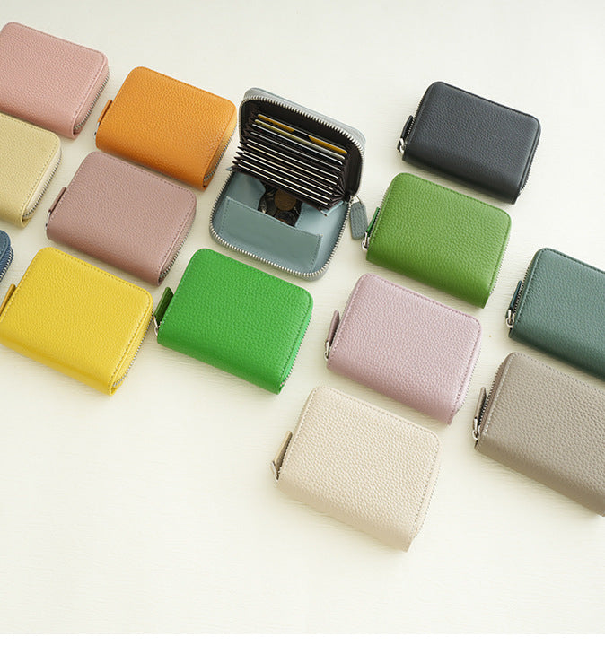 Compact top-grain cowhide zip wallets in assorted colors, with one wallet open to show accordion card slots and coin pocket
