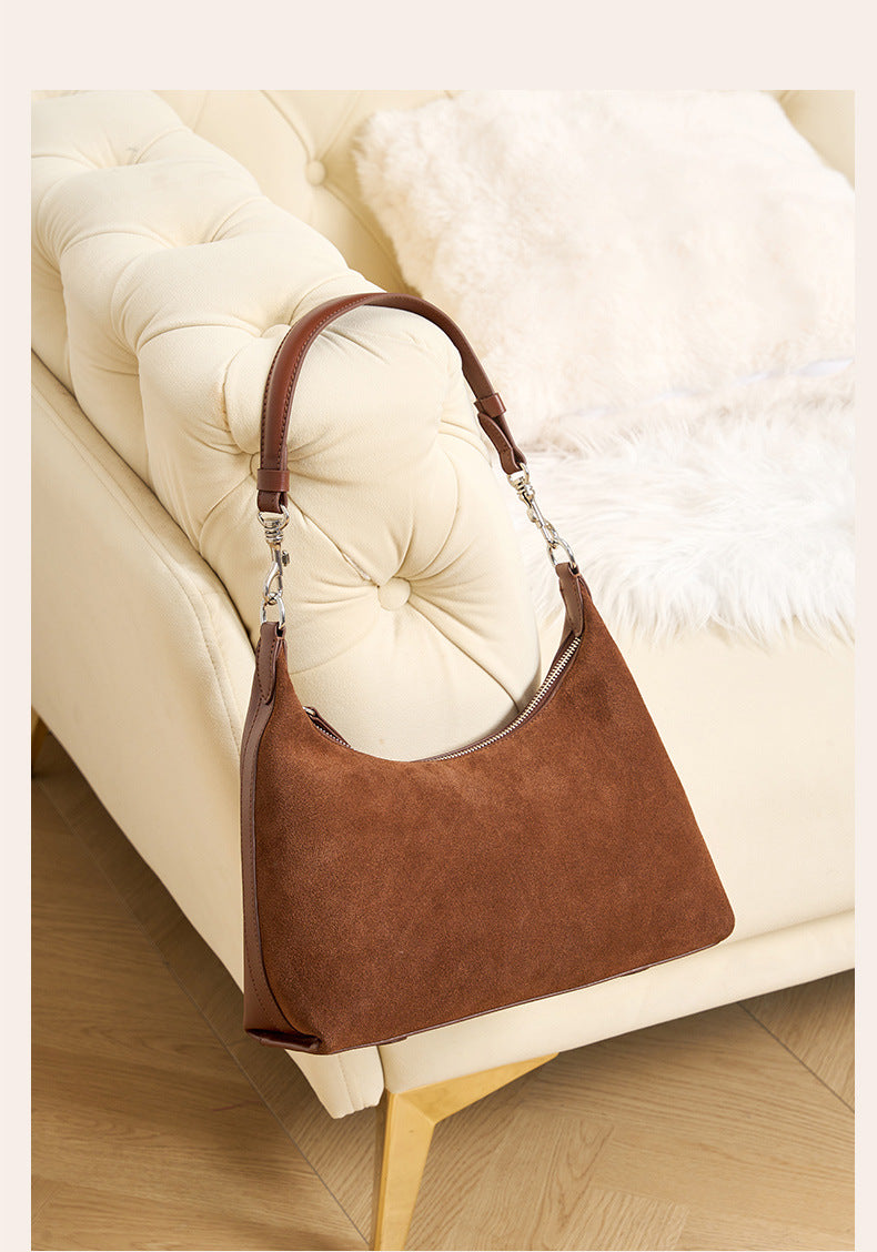 Brown shoulder bag resting on a sofa