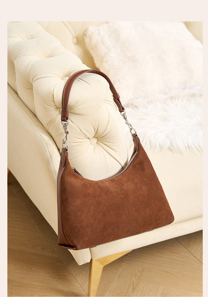 Brown shoulder bag resting on a sofa