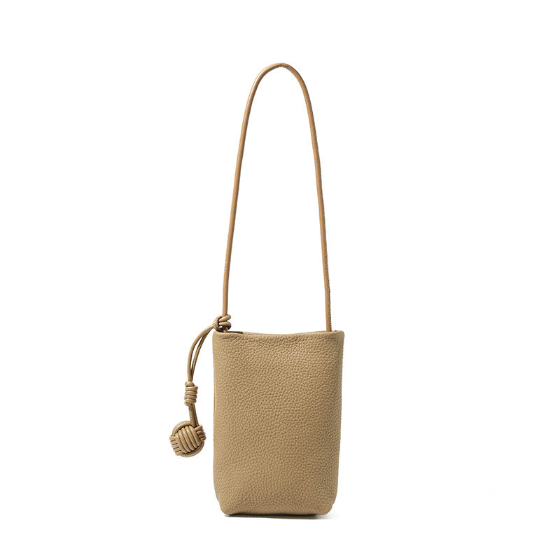Trench gray pebbled cowhide mini bucket phone crossbody bag with knotted strap detail on white background
