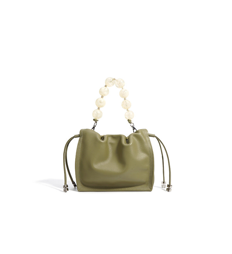 Back view of champagne mini bucket bag with beaded handle visible