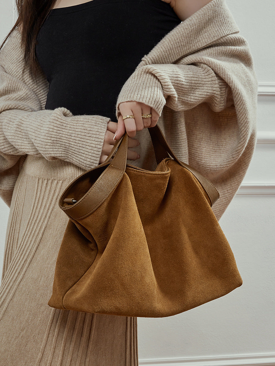 Side angle view of vintage leather shoulder bag showing structured silhouette