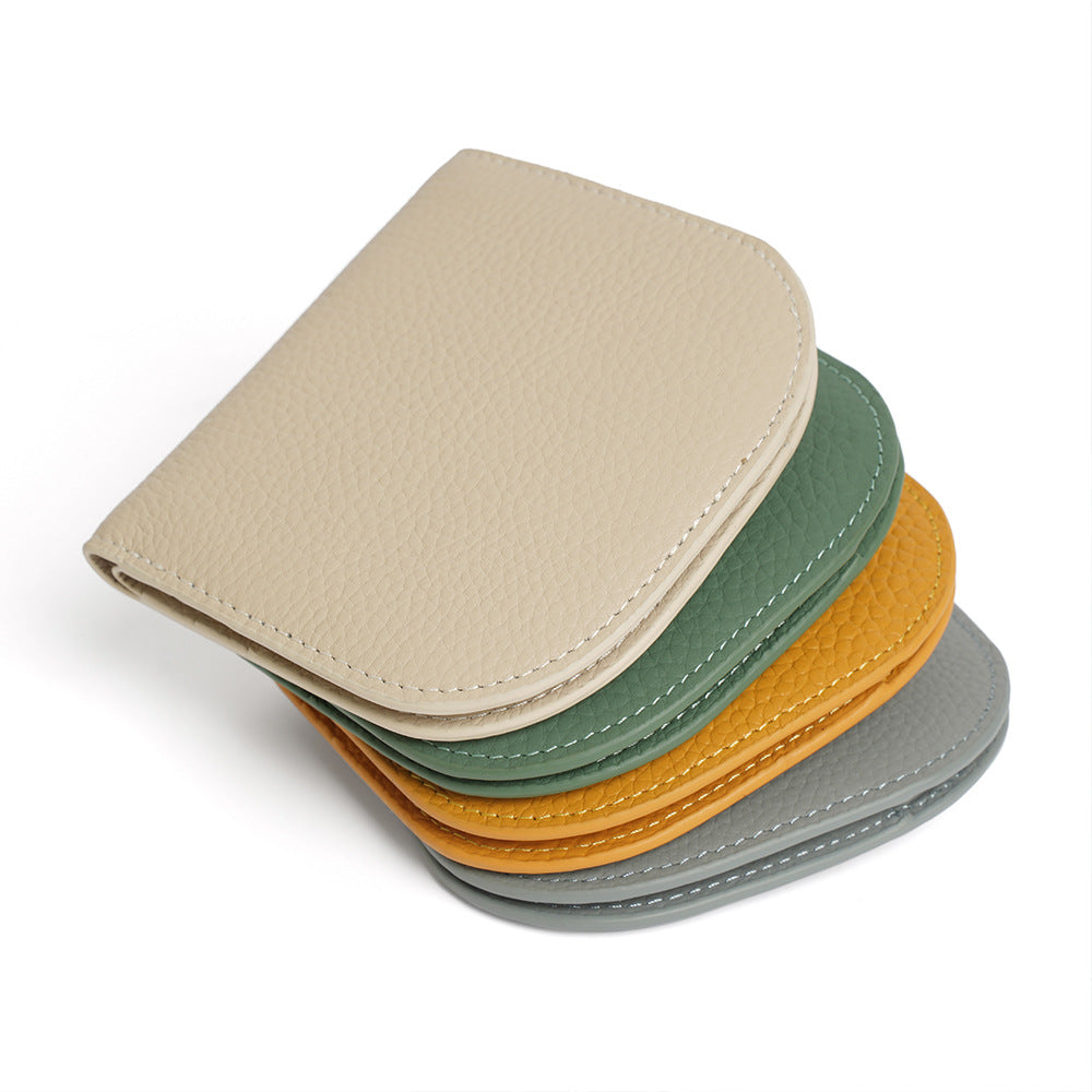 Stack of four pebbled cowhide leather bifold wallets in ivory, green, yellow and grey